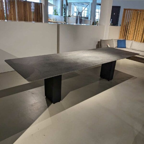 Image of Doble Slim contemporary garden table with black base and Cemento Luminoso ceramic top by FueraDentro