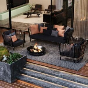Image of bird's eye view of Houdini luxury garden sofa and lounger chairs, shown placed around Sphere marble fire pit on opulent terrace