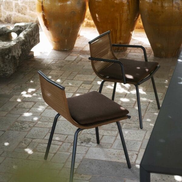 Image of pair of Laze designer garden chairs next to Plein Air outdoor dining table, in shadows beneath pergola