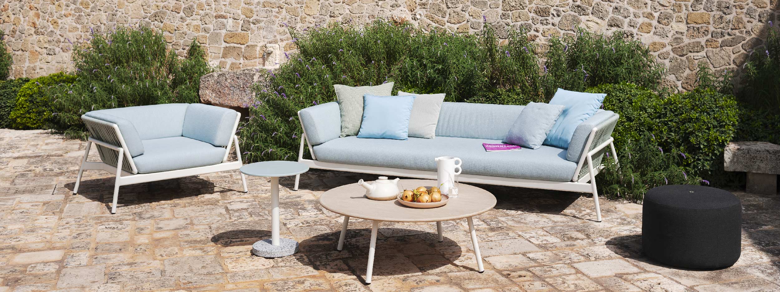 Image of Piper minimalist white garden sofa & low table on sunny rustic terrace