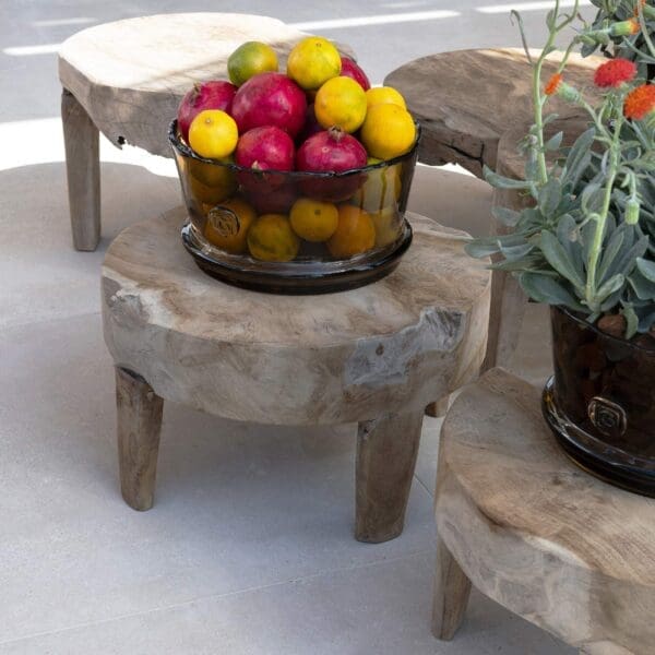 Image of group of Gommaire Samba low tables, one of which carries a large glass bowl of pomegranates and lemons