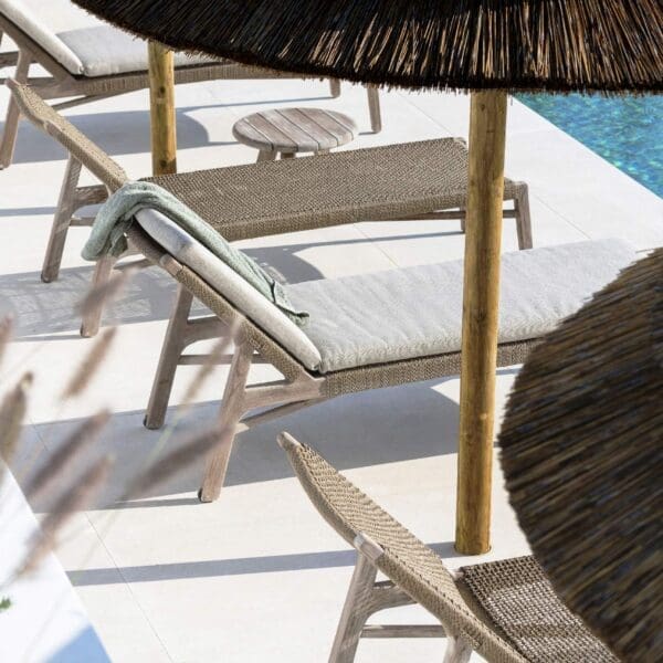 Image of row of Gommaire Fiona chaise longue along poolside beneath grass sunshades