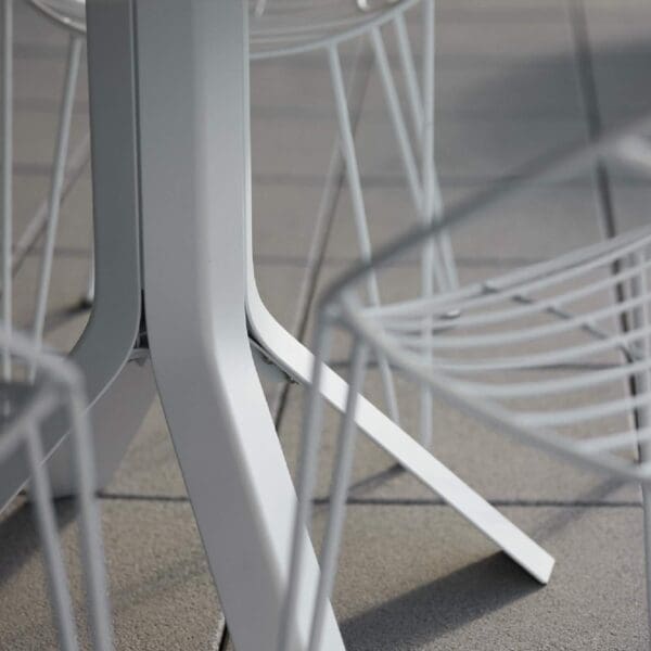 Image of detail of white aluminium base & legs of Fizz ceramic table and Fizz chairs by Joli.