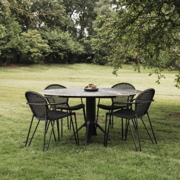Image of Fizz circular table with Fizz minimalist garden chairs by Joli, shown on grass with field and trees in the background