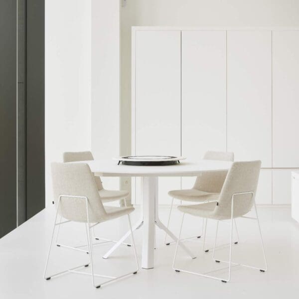 Image of white Fizz ceramic table and white Curve chairs by Joli in large white room.
