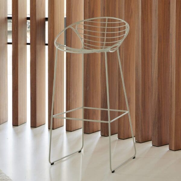 Image of Wire high bar stool on polished floor surface, with vertical slatted wooden screen in the background