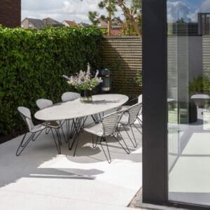 Image of Wire oval ceramic dining table and Wire retro dining chairs by Joli on a sunny terrace