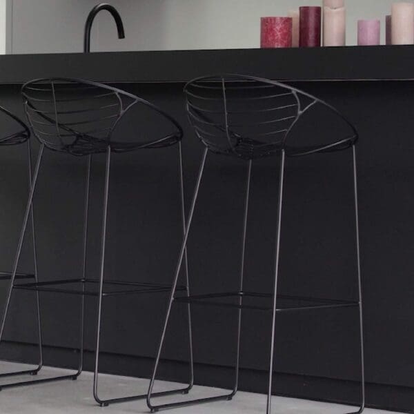 Image of row of black Wire contemporary iron bar chairs again bar countertop