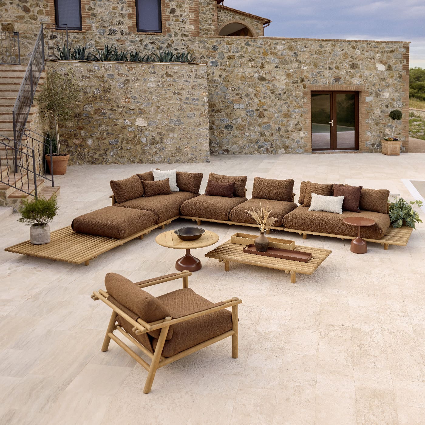 Image of birdseye view of Cane-line Sticks Platform garden corner sofa on sunny terrace with villa in the background