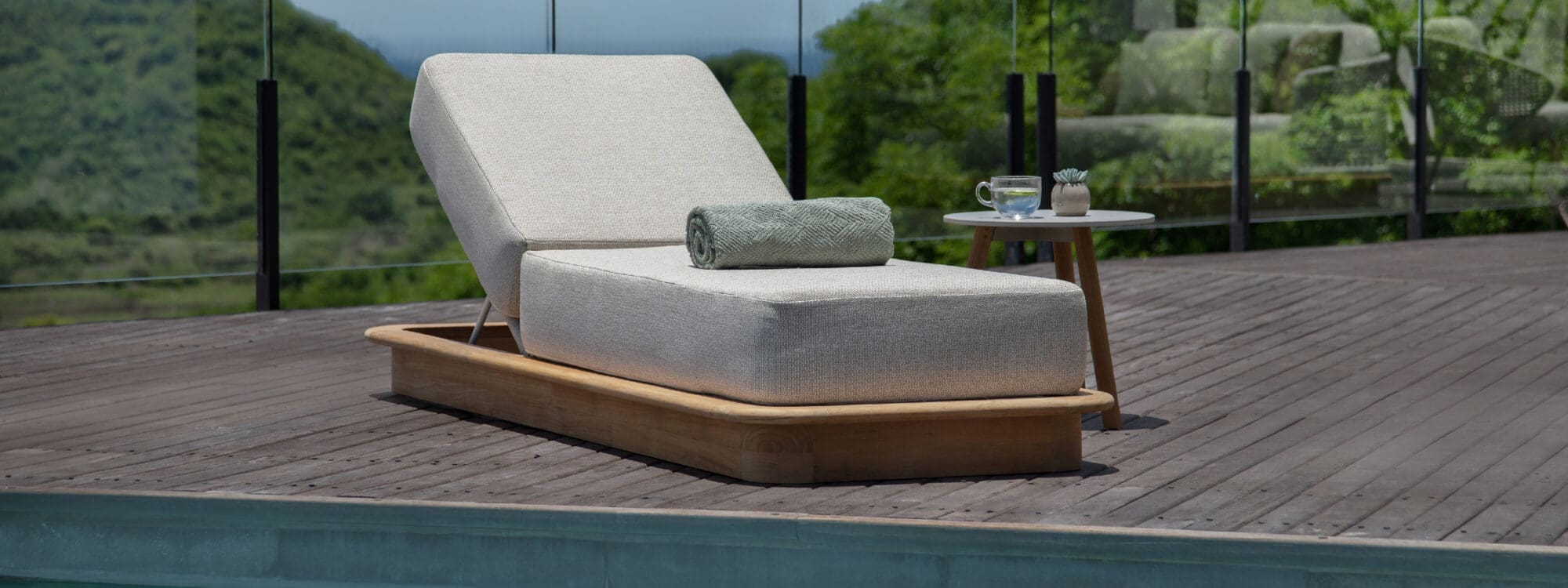Image of Jati & Kebon Acri sun lounger with a towel rolled up on the lounger's cushion