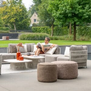 Image of man relaxing whilst sat reading newspaper in Cala luxury garden sofa