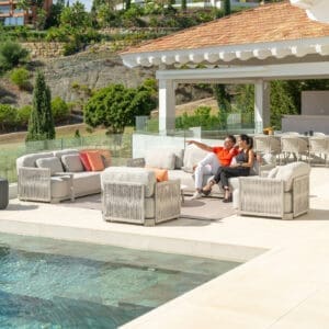 Image of couple relaxing in Durbuy modern outdoor lounge furniture on sunny poolside