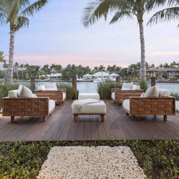 Image of Tuuci Luma luxury outdoor lounge furniture beneath palm trees with Florida waterway in the background