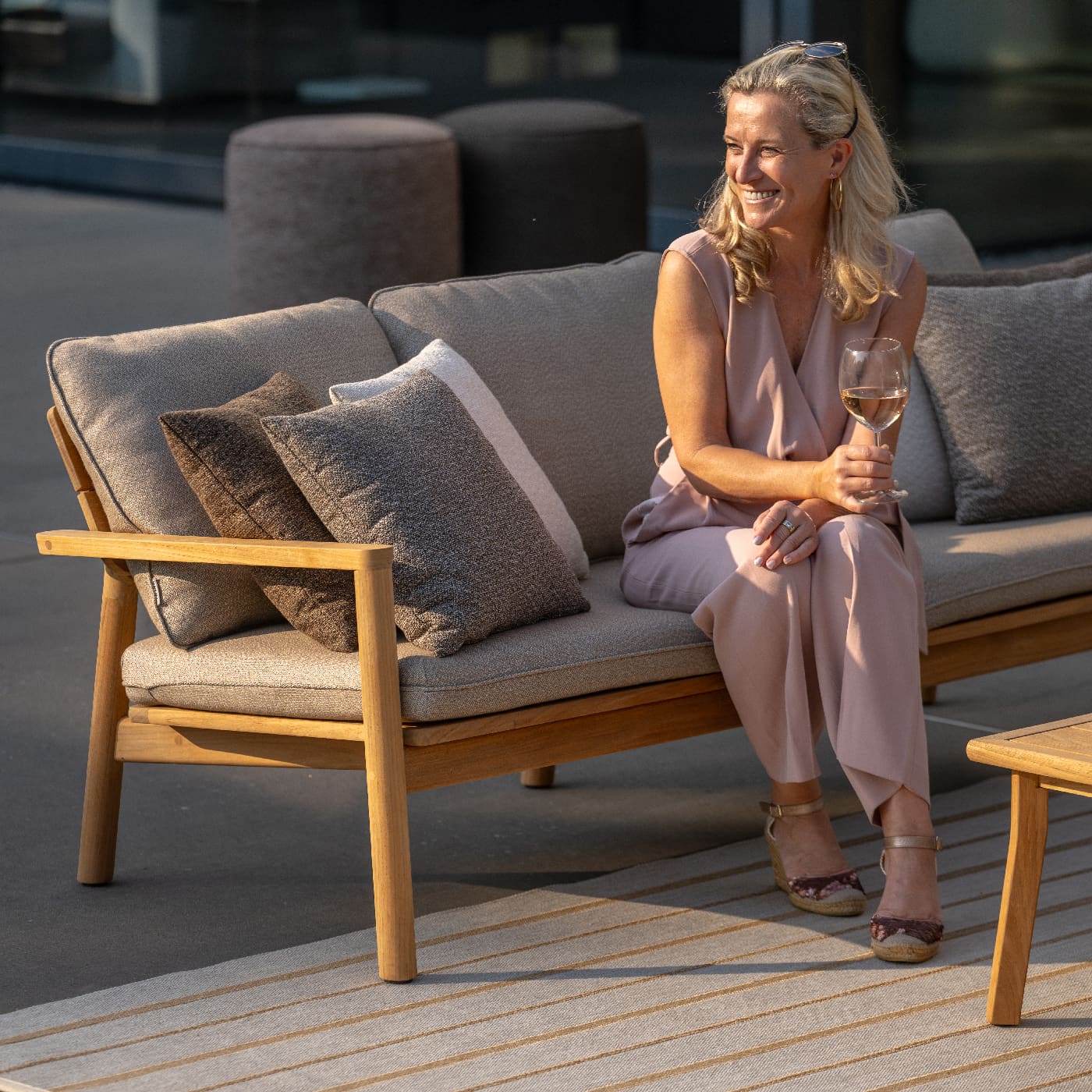 Image of womn sat on Lynn luxury 3 seater teak sofa