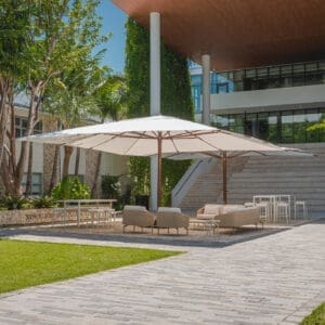 Image of pair of Tuuci Mega Max large parasols over lounge furniture in sunshine