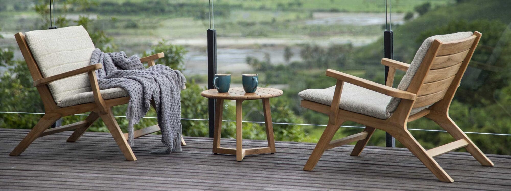 Image of pair of Koozy teak garden lounge chairs with light-grey Sunbrella cushions by Jati & Kebon