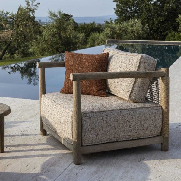 Image of Gommaire Mieke luxury garden lounge chair on decking with still water in the background