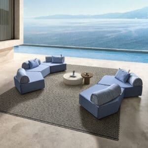 Image of pair of Anoko modern blue garden sofas on minimalist balcony with swimming pool and sea in the background