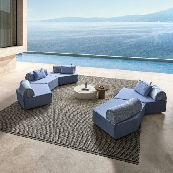 Image of pair of Anoko modern blue garden sofas on minimalist balcony with swimming pool and sea in the background