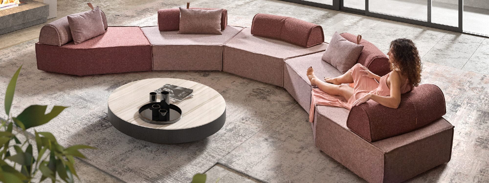 Image of woman lying on top of serpentine-shaped Komoom Anoko sofa