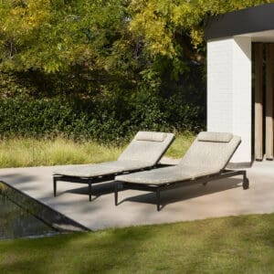Image of pair of Marguerite sun loungers next to still waters of a horizon swimming pool
