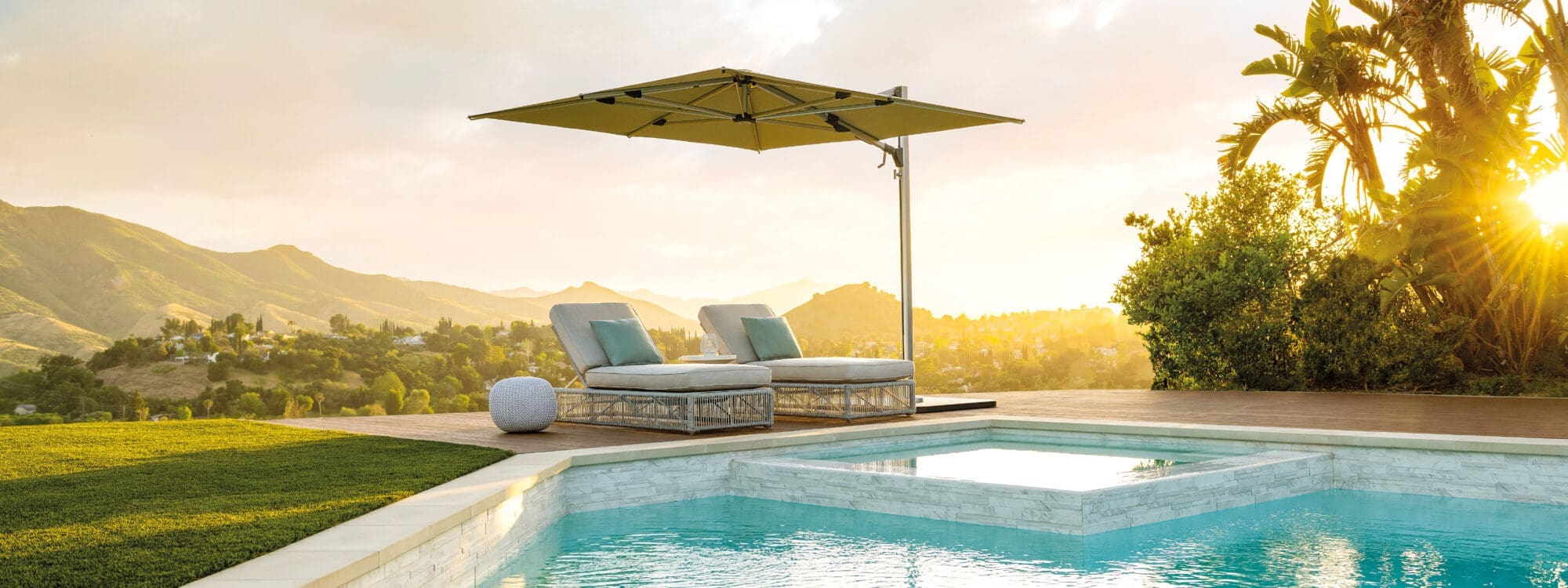 Image of Shademaker Solaris parasol at dusk with still waters of swimming pool in the foreground