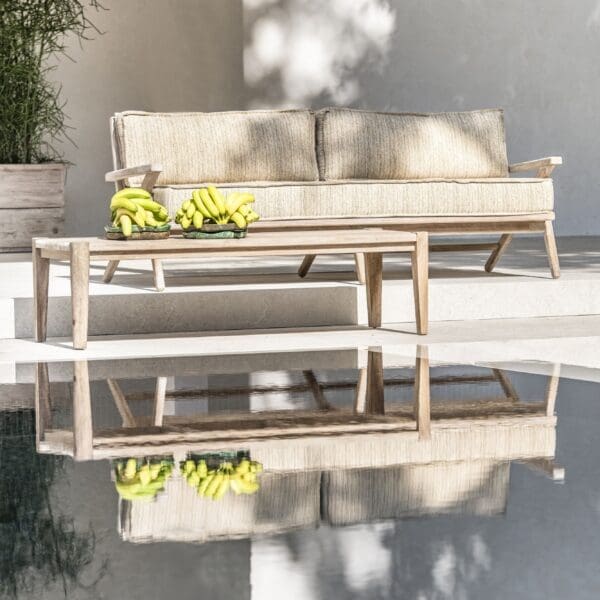 Image of Gommaire Alabama 2.5 seater teak sofa reflecting in still waters of swimming pool