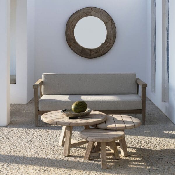 Image of grouped 3 Anton circular low teak tables in front of Copenhague teak sofa by Gommaire