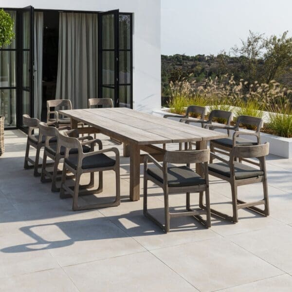 Image of Gommaire Abe large teak dining table with 10 Sally chairs placed around the table