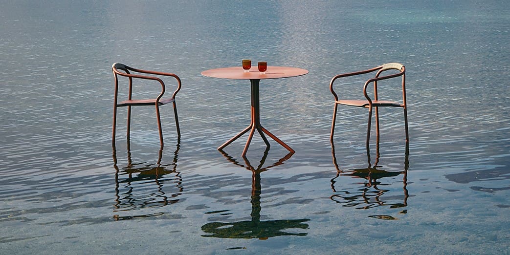 Image of pair of Salo chairs and Salo round bistro table reflected in the water of Italian lake