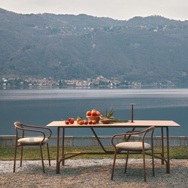 Image of Salò terracotta dining furniture by Unopiu with lake and mountains in the background