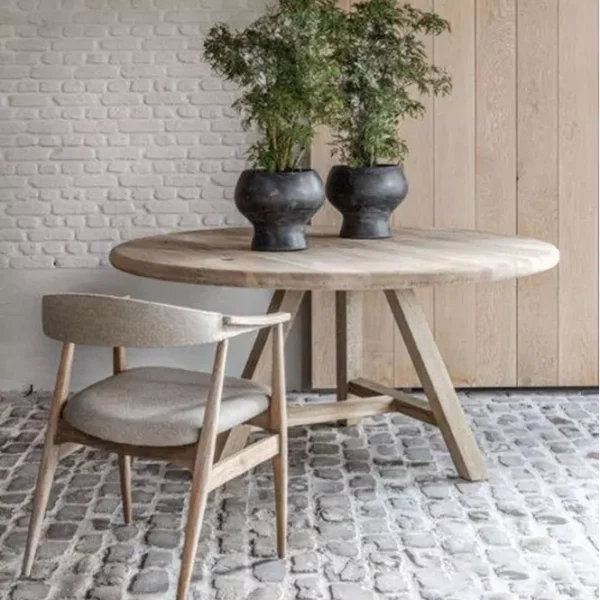 Image of Gommaire Anton round teak table on cobbled stone floor