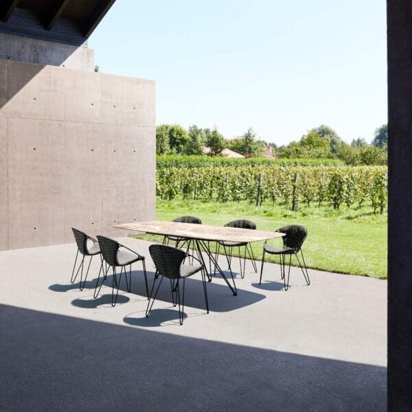 Image of Joli Wire Faux Ellipse garden table and Fizz chairs on sunny moedern terrace with vineyard in the background