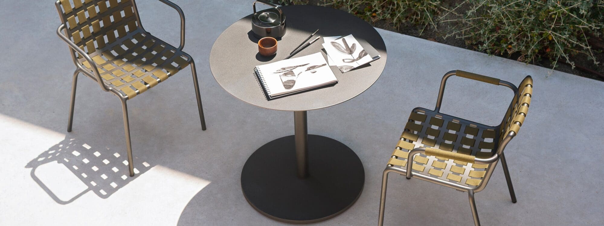 Image of RODA Erice armchairs and Button bistro table in sun and shade on terrace