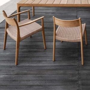 Image of 2 Gloster Lima dining chairs on decking, one with arms and the other without