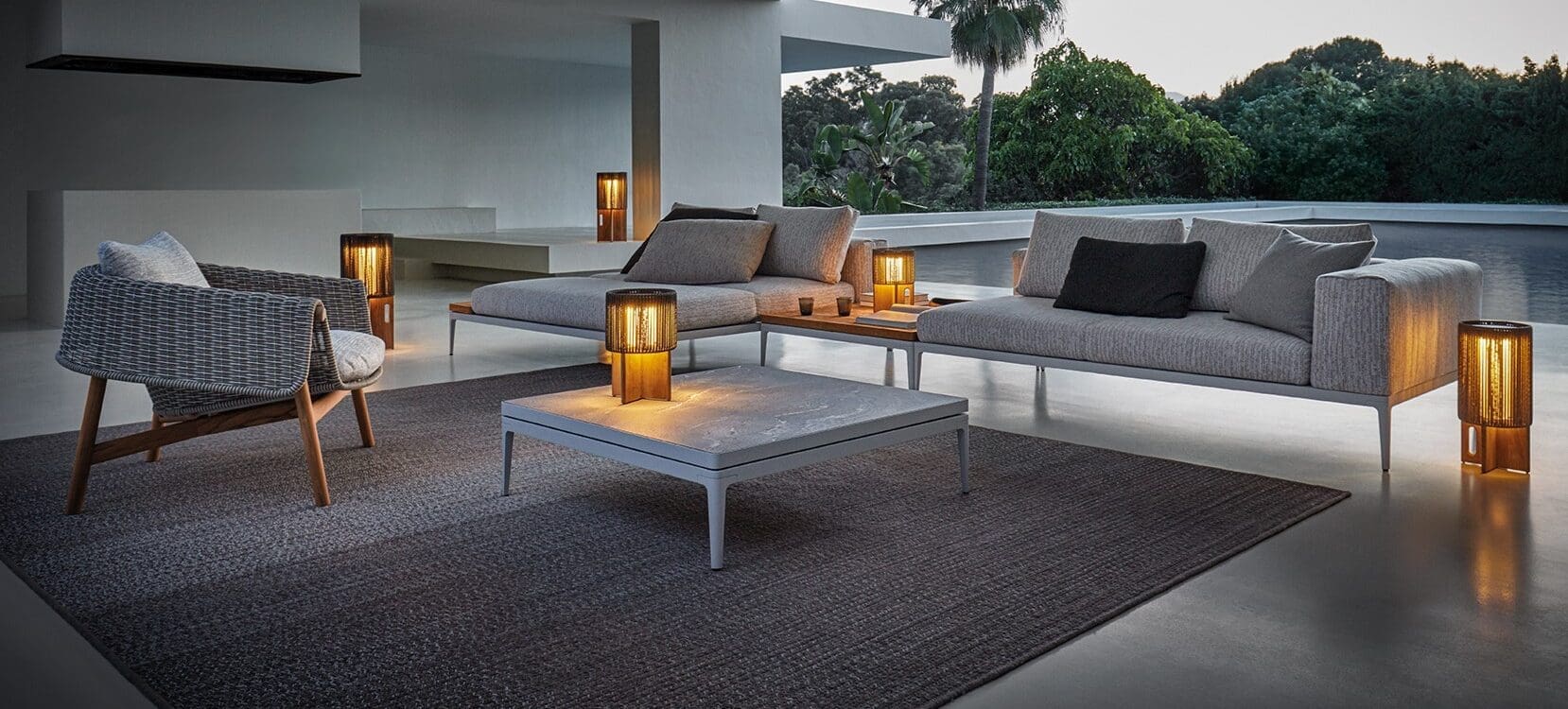 Image of Gloster Wrap lounge chair and Grid sofa at dusk