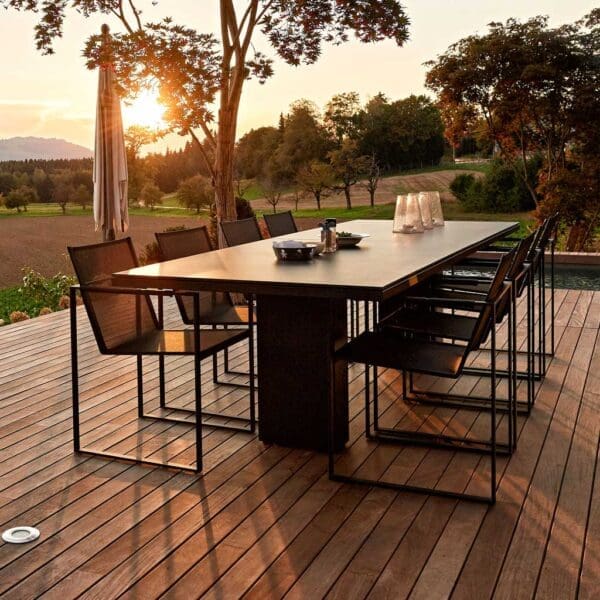 Image of FueraDentro Doble table & Butaque chairs on terrace at sunset